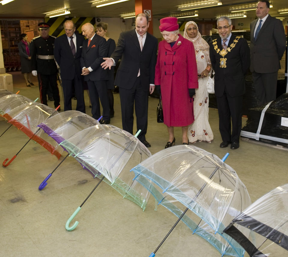 LONDON - MARCH 25:  Prince Philip, Duke of Edinburgh (2L) and Queen Elizabeth II (4R) visit Fulton Umbrellas factory on the Isle of Dogs on March 25, 2009 in London, England. During the visit the Queen Duke of Edinburgh were shown various stages in the production and assembly of the umberellas.  (Photo by Arthur Edwards-Pool/Getty Images)