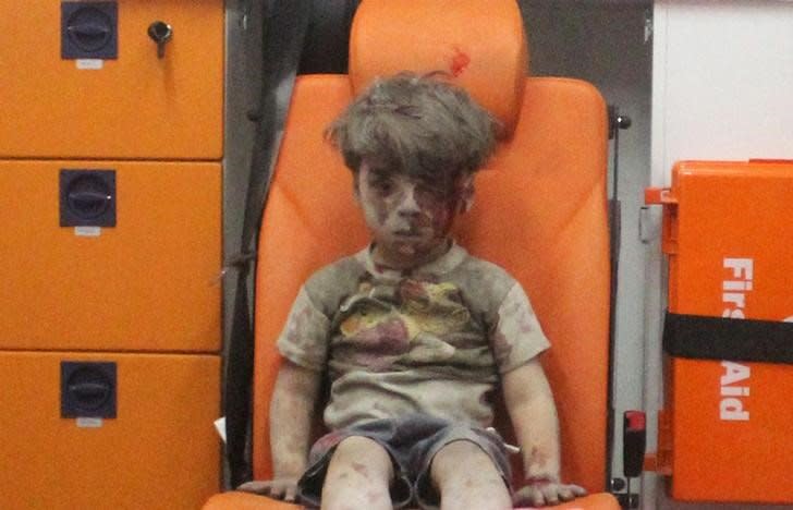 Five-year-old Omran Daqneesh, with bloodied face, sits inside an ambulance after he was rescued following an airstrike in the rebel-held al-Qaterji neighbourhood of Aleppo, Syria August 17, 2016.  REUTERS/Mahmoud Rslan