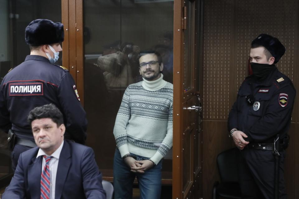 Russian opposition activist and former municipal deputy of the Krasnoselsky district Ilya Yashin stands inside a glass cubicle in a courtroom, prior to a hearing in Moscow, Russia, Friday, Dec. 9, 2022. Yashin faces a trial on charges stemming from his criticism of the Kremlin's action in Ukraine. (Yury Kochetkov/Pool Photo via AP)