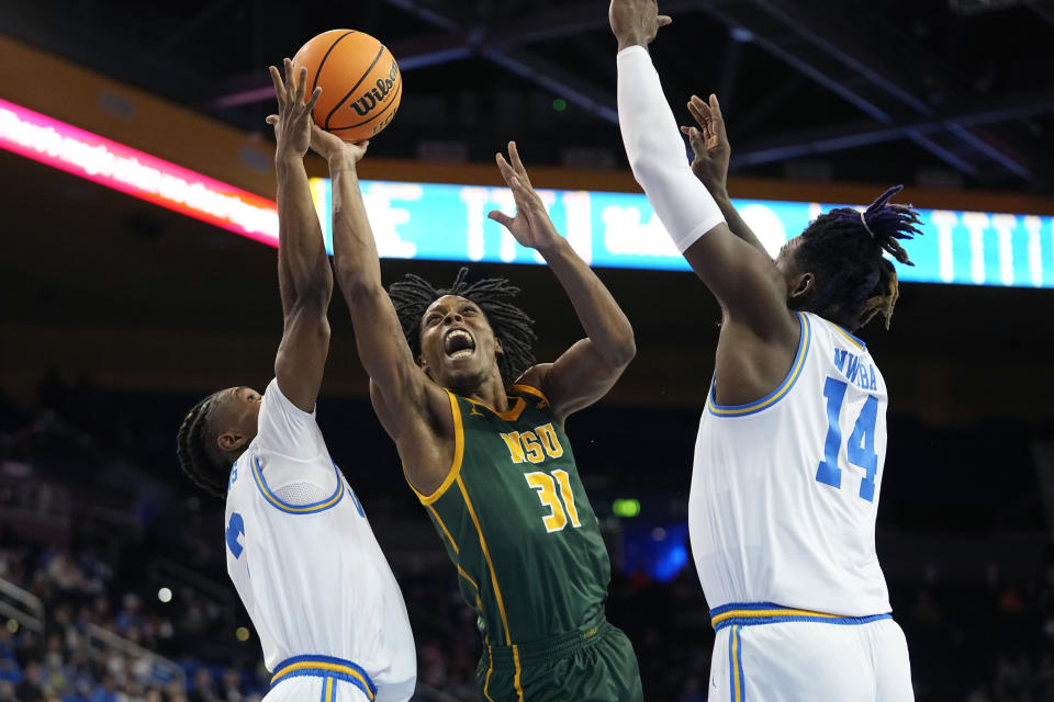 Norfolk State guard Cahiem Brown, center, shoots as UCLA guard Dylan Andrews, left, and forward Kenneth Nwuba defend during the first half of an NCAA college basketball game Monday, Nov. 14, 2022, in Los Angeles. (AP Photo/Mark J. Terrill)