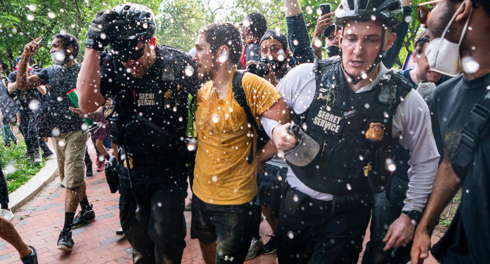 US Secret Service detained a protester as people gathered outside the White House on Friday. Source: AAP