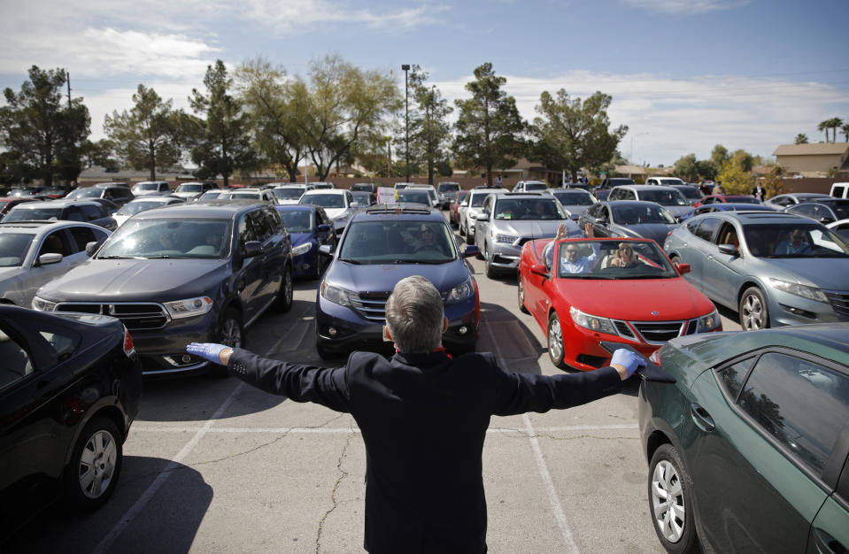 Pastor Paul Marc Goulet prays to people in their cars at an Easter drive-in service at the International Church of Las Vegas due to the coronavirus outbreak, Sunday, April 12, 2020, in Las Vegas. (AP Photo/John Locher)