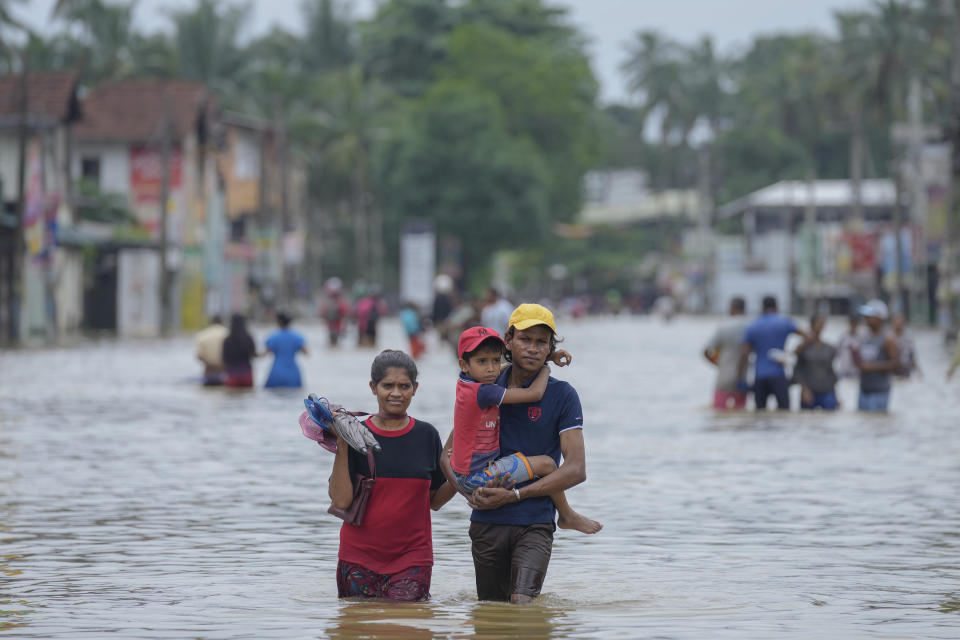 People wade through a flooded street in Biyagama, a suburb of Colombo, Sri Lanka, Monday, Jun. 3, 2023. (AP Photo/Eranga Jayawardena)