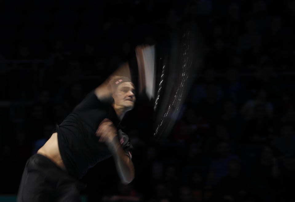 El suizo Roger Federer saca ante el italiano Matteo Berrettini durante su partido por la Copa Masters de la ATP en Londres, el martes 12 de noviembre de 2019. (AP Foto/Alastair Grant)