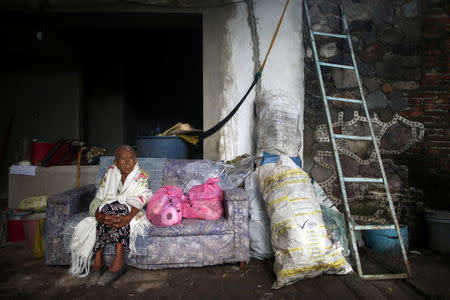 Eduarda Espana, 93, sits on a sofa and next to bags of basic supplies, after part of her house collapsed in an earthquake, in Axochiapan, Mexico September 25, 2017. REUTERS/Edgard Garrido