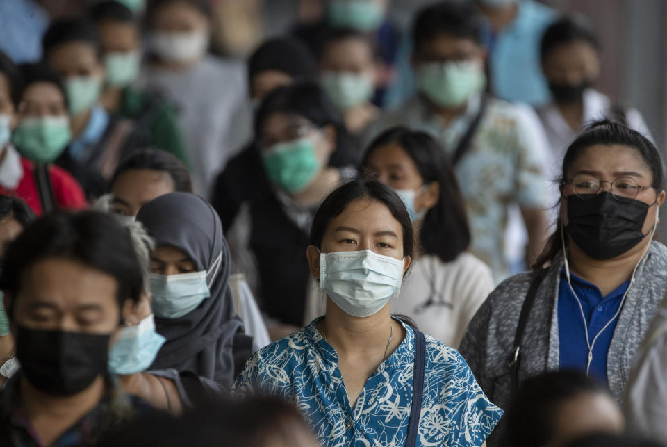 Office workers wearing face masks to help curb the spread of the coronavirus walk to work at Saen Saep pier in Bangkok, Thailand, Friday, April 16, 2021. (AP Photo/Sakchai Lalit)