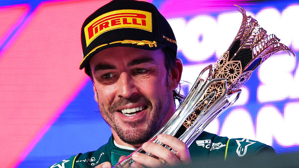 Fernando Alonso holds up his trophy for third place on the podium at the Saudi Arabian F1 Grand Prix.