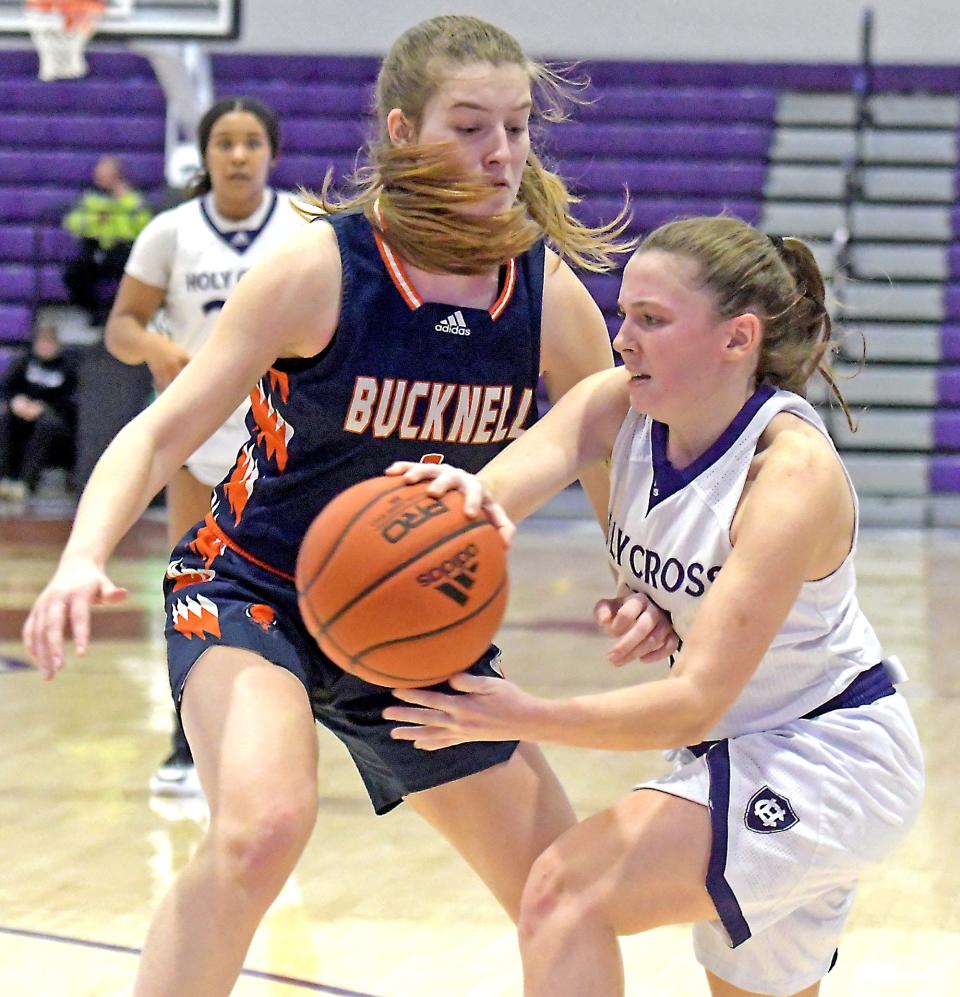 Holy Cross' Cara McCormack dishes off a pass as she is defended by Bucknell's Ashley O'Connor.