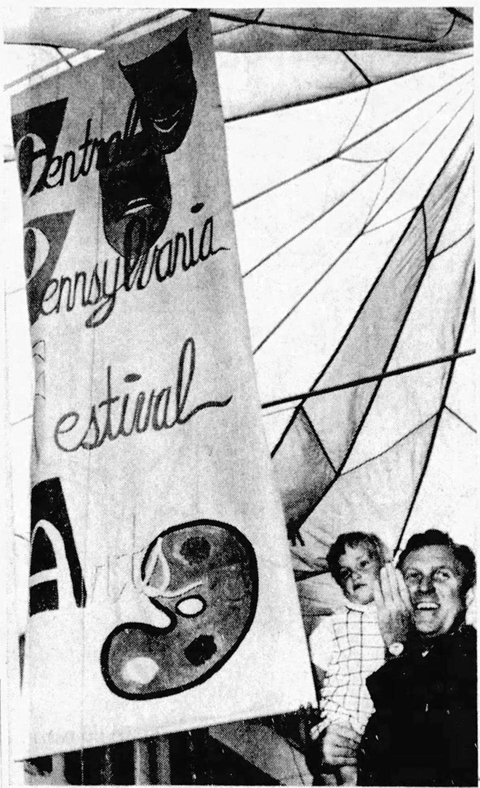 Gov. Raymond Shafer helps open the first Central Pennsylvania Festival of the Arts on July 22, 1967, by unfurling the festival banner.