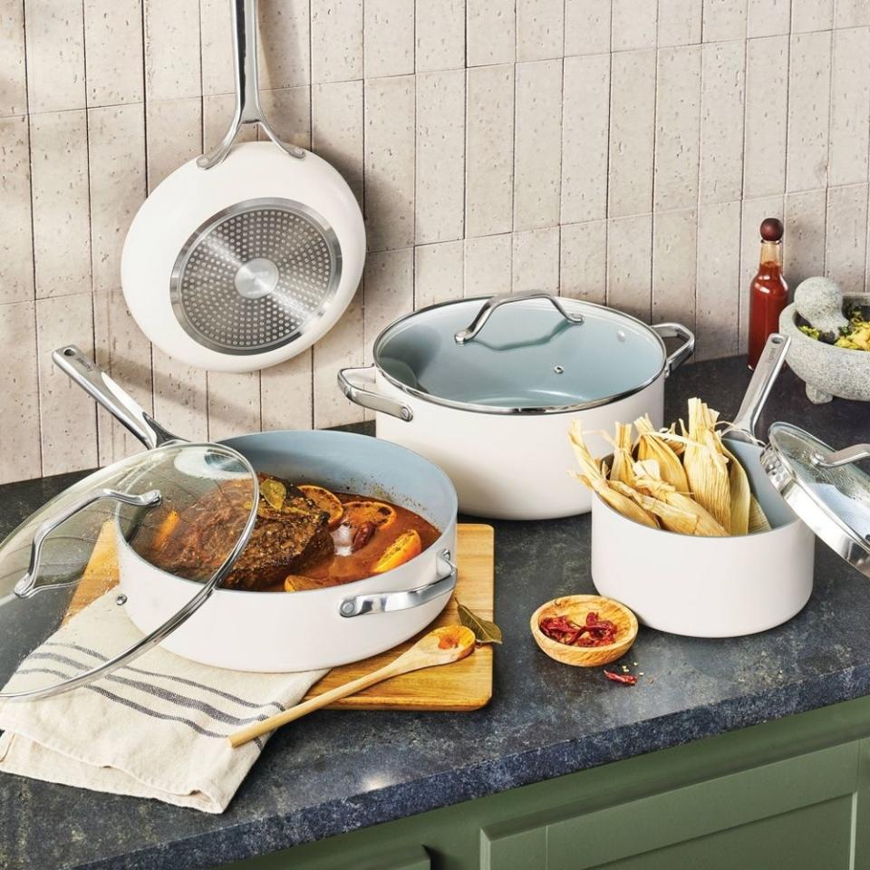 The white ceramic cookware set on a counter with food in it