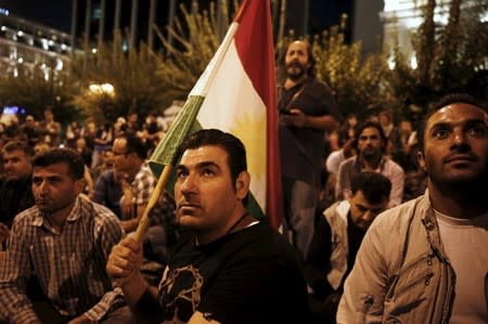 A pro-Kurdish demonstrator holds the flag of the Syrian Kurdish Democratic Union party (PYD) during a rally in Athens in this October 8, 2014 file photo. REUTERS/Yiorgos Karahalis/Files