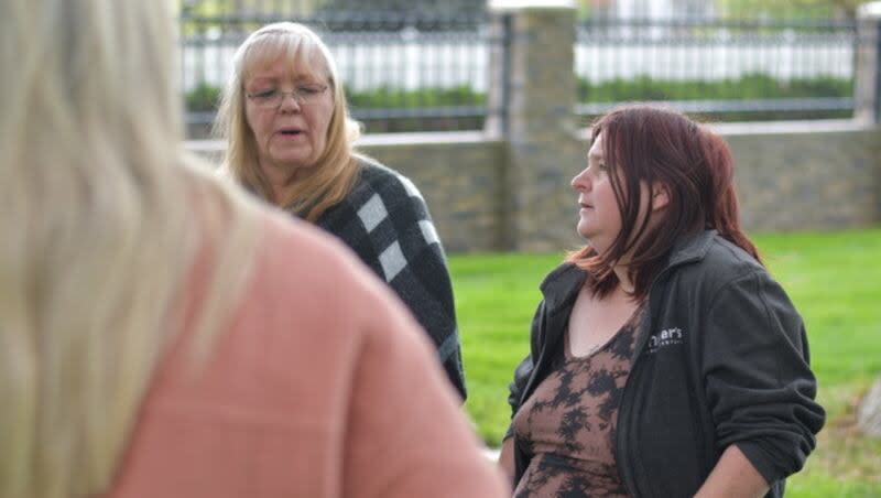 Carla Maas, left, and her daughter Dana Booth Christensen, talk at the grave of Buddy Booth in April in Salt Lake City. Booth was Maas' husband and Christensen's father.