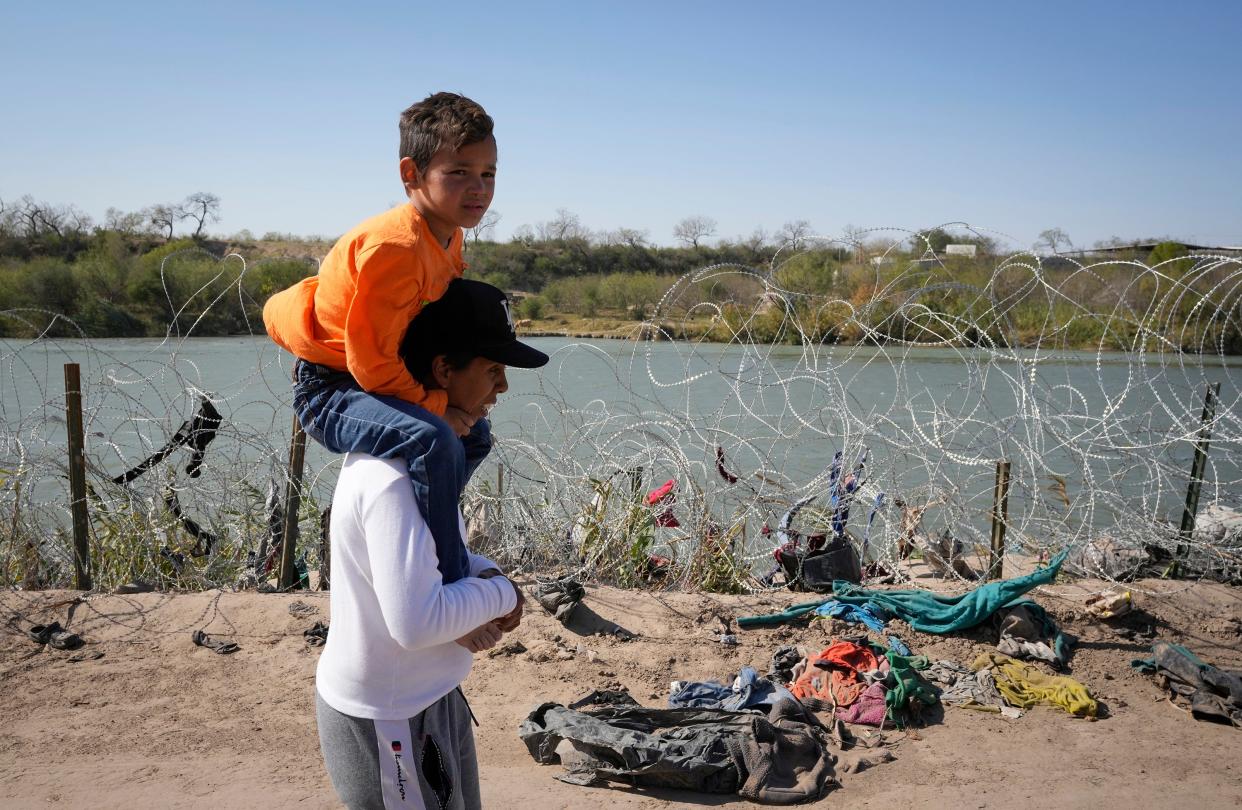Angelica Reyes walks along the banks of the Rio Grande with Fabian Los Diaz, 6, to surrender to U.S. Border Patrol after they entered Texas at Eagle Pass with a a group of fellow migrants from Venezuela on Monday January 8, 2024.