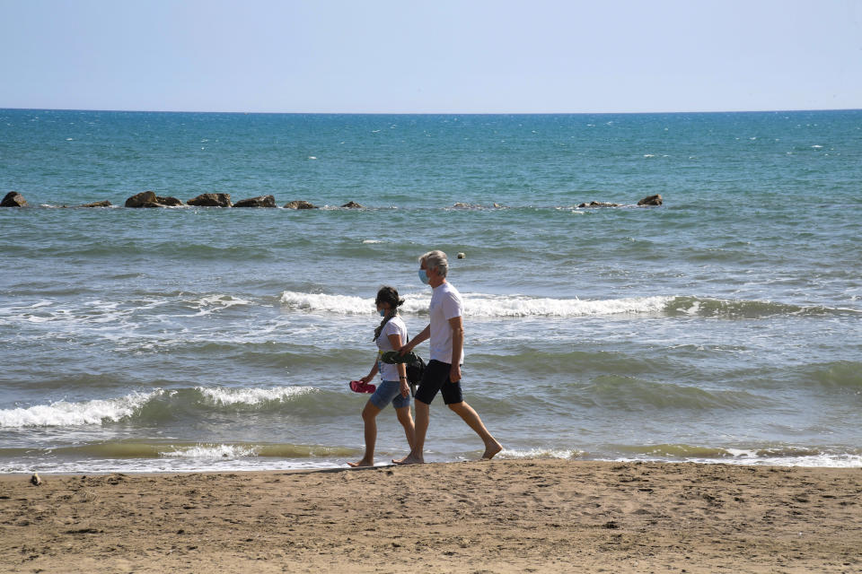 CASTIGLIONE DELLA PESCAIA, ITALY - MAY 17: A few people walks at the beach in a seaside town in the province of Grosseto, Castiglione della Pescaia in South-Western Tuscany, Italy on May 17, 2020.The Italian government approved a decree that allows international travel to and from the country from June 3. People will also be allowed to move freely within the country from the same date. (Photo by Carlo Bressan/Anadolu Agency via Getty Images)