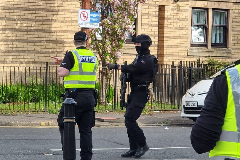 An armed officer at the scene on Kenmure Street.