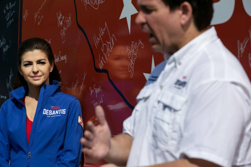 Casey DeSantis listens to her husband, Gov. Ron DeSantis of Florida, talk to reporters in Cedar Falls, Iowa, on Saturday.  (Maddie McGarvey for NBC News)