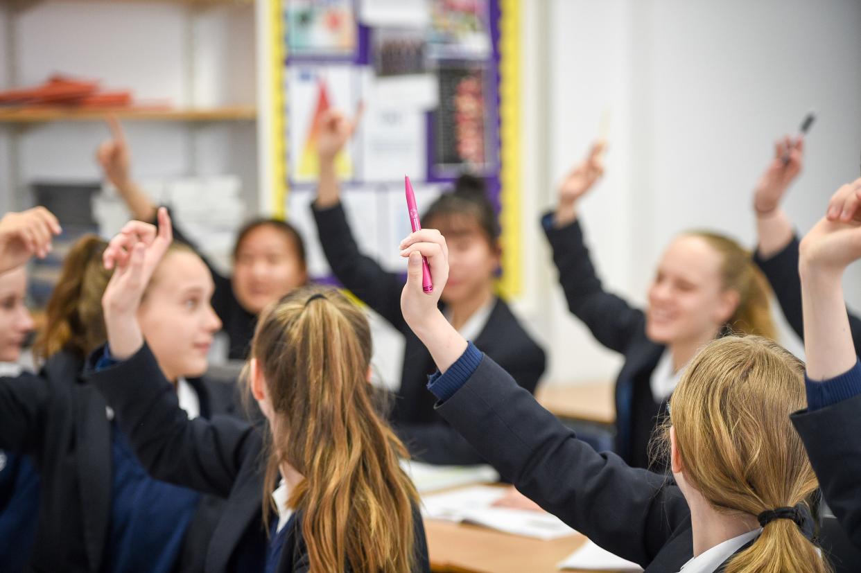 <p>Students raise their hands in class at Royal High School Bath, which is a day and boarding school for girls </p> (PA)