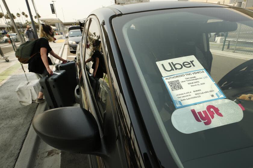 LAX AIRPORT, CA - AUGUST 20: Passengers connect with drivers at the Rideshare Lot at LAX as Uber and Lyft drivers held a moving rally as part of a statewide day of action to demand that both ride-hailing companies follow California law and grant drivers "basic employee rights" and to "denounce the corporations' efforts to avoid their responsibilities to workers." Uber and Lyft threatened to suspend services in California Thursday night but a court granted Uber and Left a stay to a preliminary injunction requiring both rideshare companies to reclassify their drivers as employees, meaning the rideshare companies will not suspend service in California tonight as they threatened. Los Angeles on Thursday, Aug. 20, 2020 in LAX Airport, CA. (Al Seib / Los Angeles Times