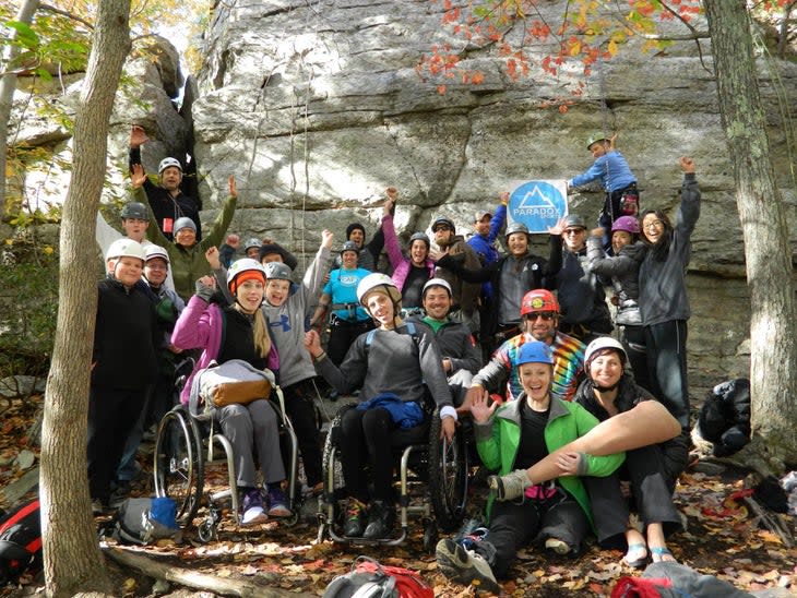 A group of Paradox trip participants at the Gunks. Some are in wheelchairs. One woman is holding her prosthesis. It looks like a good time.