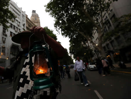 A man wearing traditional Gaucho clothes holds a lantern during a protest against a cost increase in public and utility services in Buenos Aires, Argentina, January 10, 2019. REUTERS/Marcos Brindicci