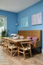 <p>Not only does a banquette reduce the footprint needed for chairs around a dining table, it can also be employed as a handsome piece of furniture in its own right.</p><p>'The expanse of wall this seat sits on is huge, so I designed this as a statement piece to really be a focal point,' explains interior designer Laura Stephens. 'The high back, slim side profile and tan leather complement the Hans Wegner Wishbone chair and pop against the lively blue painted wall.'</p><p>Pictured: A room from a project by <a href="https://www.laurastephens.co.uk/" rel="nofollow noopener" target="_blank" data-ylk="slk:Laura Stephens" class="link ">Laura Stephens </a></p>