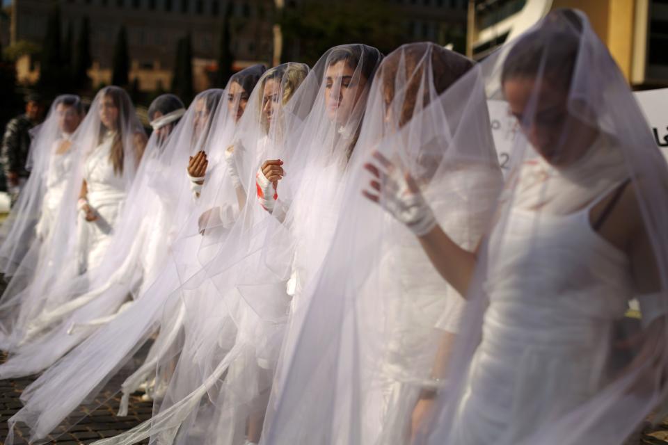 Activists from the Lebanese NGO Abaad (Dimensions), a resource center for gender equality, dressed as brides and wearing injury patches hold a protest in downtown Beirut on Dec. 6, 2016, against article 522 in the Lebanese penal code.