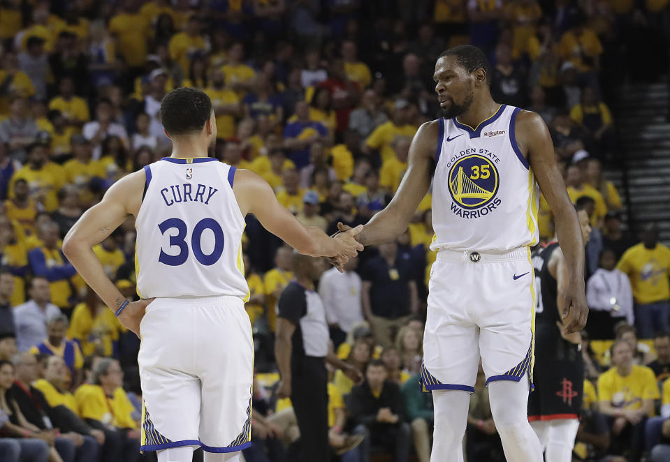 Golden State Warriors guard Stephen Curry (30) reacts with forward Kevin Durant (35) during the first half of Game 1 of a second-round NBA basketball playoff series against the Houston Rockets in Oakland, Calif., Sunday, April 28, 2019. (AP Photo/Jeff Chiu)