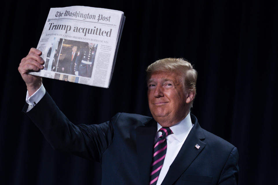 El presidente Donald Trump alza un diario con el titular "Trump absuelto" durante el 68vo Desayuno Nacional de Oración en Washington, jueves 6 de enero de 2020. (AP Foto/ Evan Vucci)