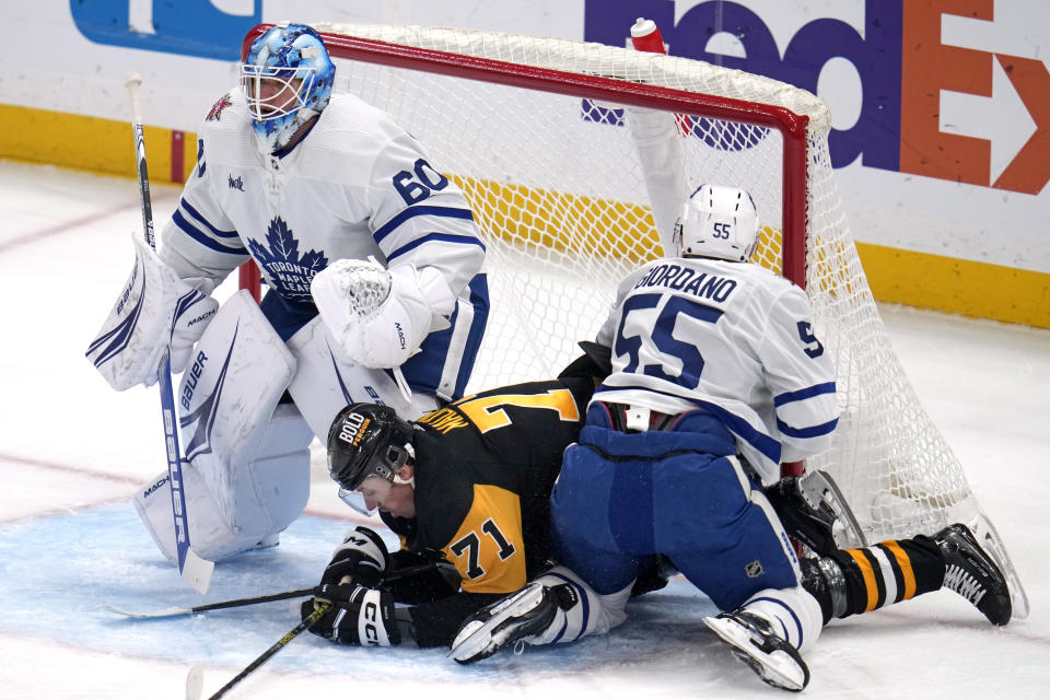 Pittsburgh Penguins' Evgeni Malkin (71) collides with Toronto Maple Leafs' Mark Giordano (55) as they slide into Maple Leafs goalie Joseph Woll (60) during the first period of an NHL hockey game in Pittsburgh, Saturday, Nov. 25, 2023. (AP Photo/Gene J. Puskar)