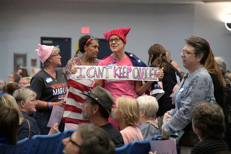 Diana Castine (C) holds a sign before U.S. Representative Ted Yoho (R-FL) speaks during a town hall meeting in Gainesville, Florida, U.S., April 10, 2017. REUTERS/Phelan Ebenhack