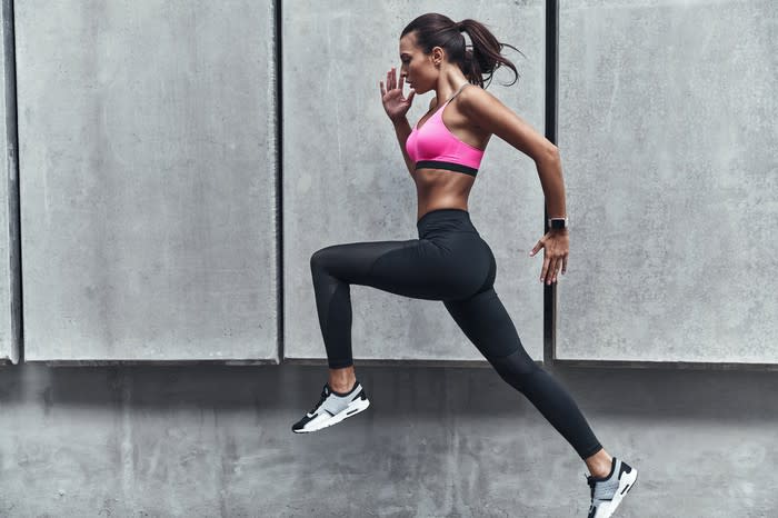 A young woman wearing athletic clothing while running.