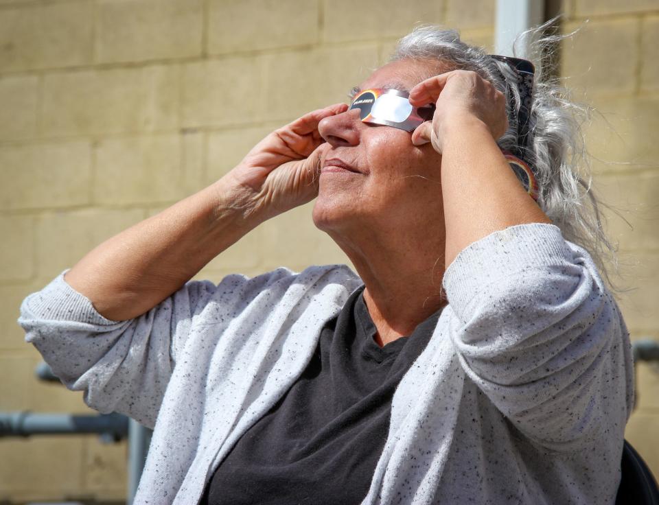 Toni Souliere of Fall River views the eclipse from Pearce Street, behind the North End Senior Center, on April 8, 2024.