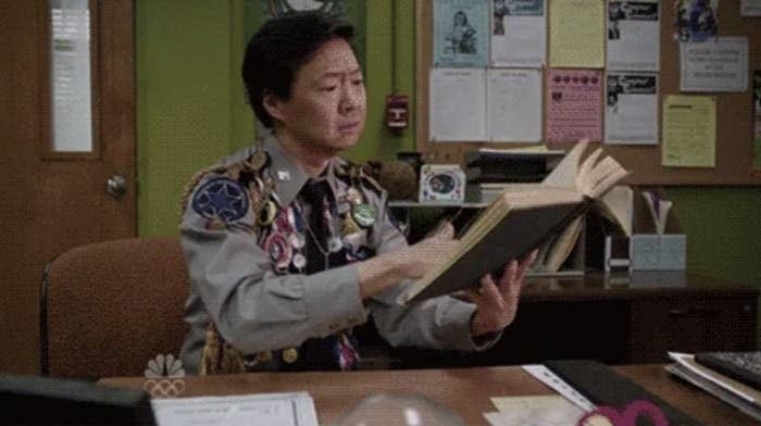 GIPHY website showing a GIF of actor Ken Jeong looking at a book. The page allows users to search for GIFs and includes related GIFs below