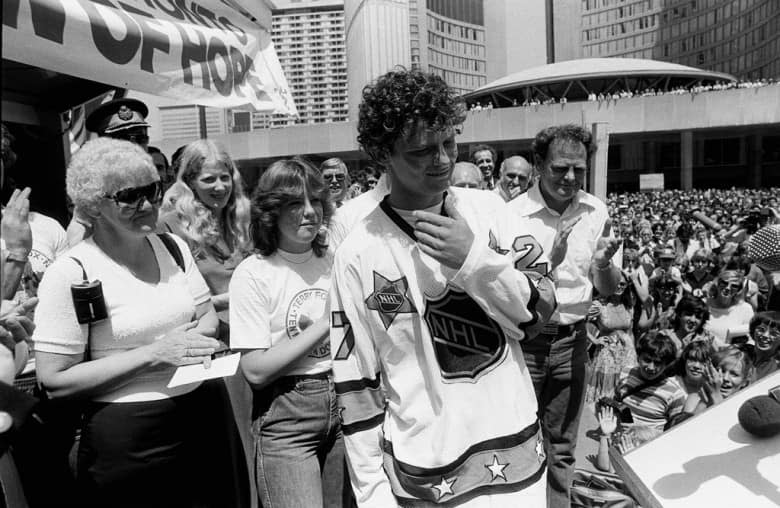 Terry Fox attends a rally at Toronto City Hall with parents Betty, left and Rolly Fox on July 11, 1980. He is wearing an NHL All Star jersey presented to him by Darryl Sittler of the Toronto Maple Leafs. (Bill Becker/CP)