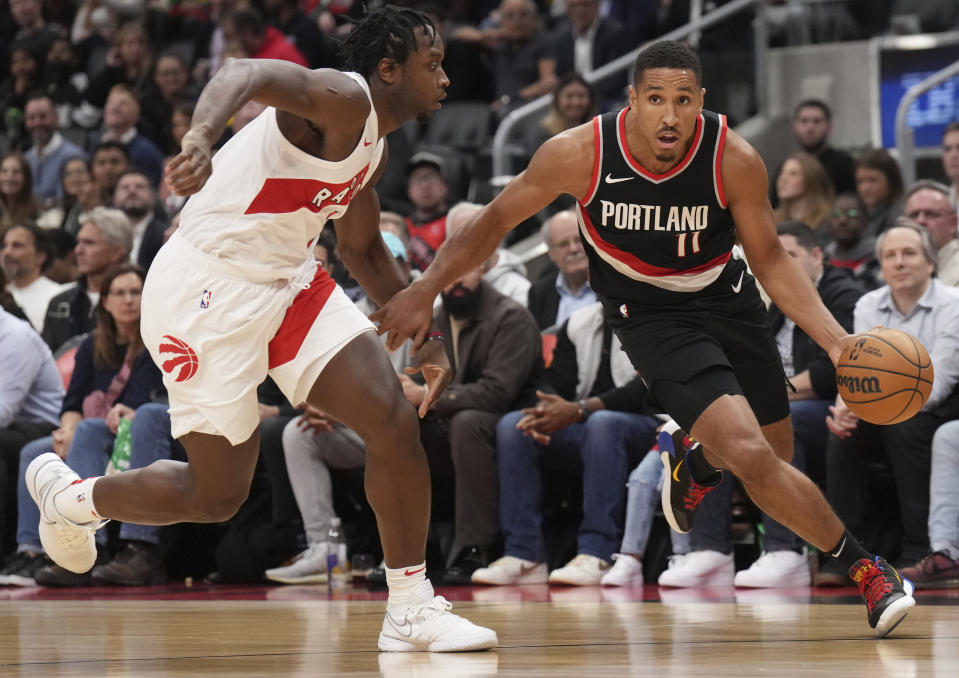 Portland Trail Blazers guard Malcolm Brogdon (11) drives around Toronto Raptors forward O.G. Anunoby, left, during second-half NBA basketball game action in Toronto, Monday, Oct. 30, 2023. (Nathan Denette/The Canadian Press via AP)