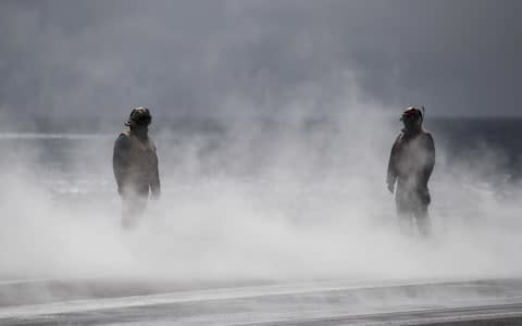 Personnel stand in steam created after a plane took off during joint military exercise, Saxon Warrior, aboard the USS George H.W. Bush on August 6, 2017 - Credit:  Dan Kitwood/ Getty Images Europe