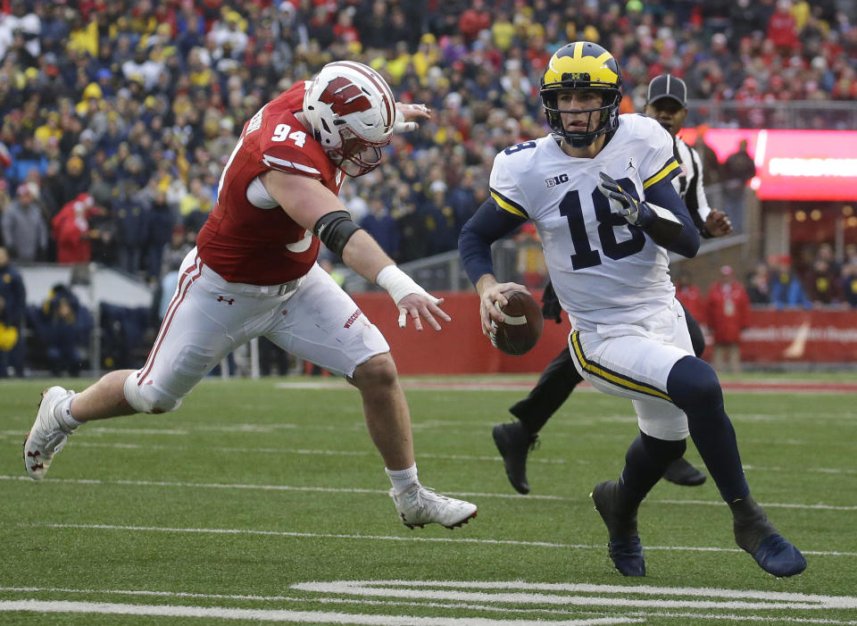 Michigan’s Brandon Peters runs past Wisconsin’s Conor Sheehy during an NCAA college football game Saturday, Nov. 18, 2017, in Madison, Wis. (AP Photo/Aaron Gash)