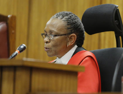 Judge Thokozile Masipa reads her verdict as Oscar Pistorius sits in the dock. (AFP)