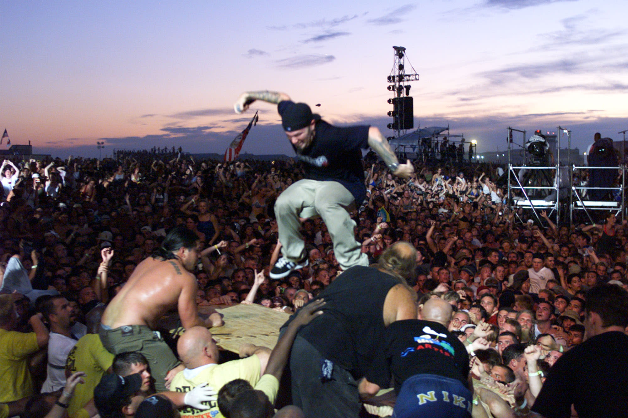 A large crowd in front of a stage in the evening.