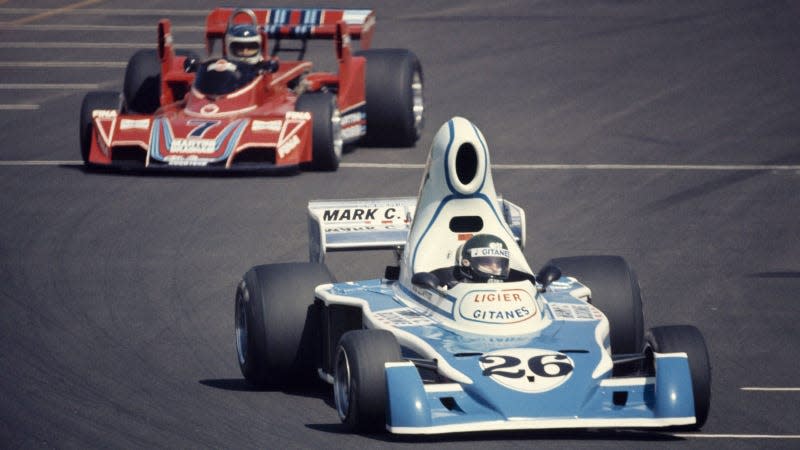 A photo of a 1976 Ligier Formula 1 car racing on track. 