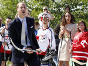 Britain's Prince William and his wife Catherine, the Duchess of Cambridge, react after the prince took a shot with a hockey stick and missed during a visit to the Somba K'e Civic Plaza in Yellowknife, Northwest Territories July 5, 2011. Prince William and his wife Catherine are on a royal tour of Canada from June 30 to July 8. REUTERS/Phil Noble