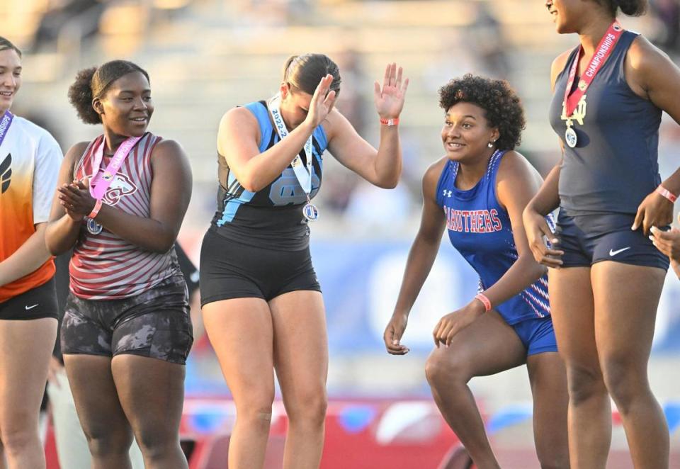 Clovis North’s Loie Madsen, left, pretends to bow to Nailea Fields from Caruthers, center, during the awards for Gir;s Discus at the 2023 CIF California Track & Field State Championship finals Saturday, May 27, 2023 in Clovis.