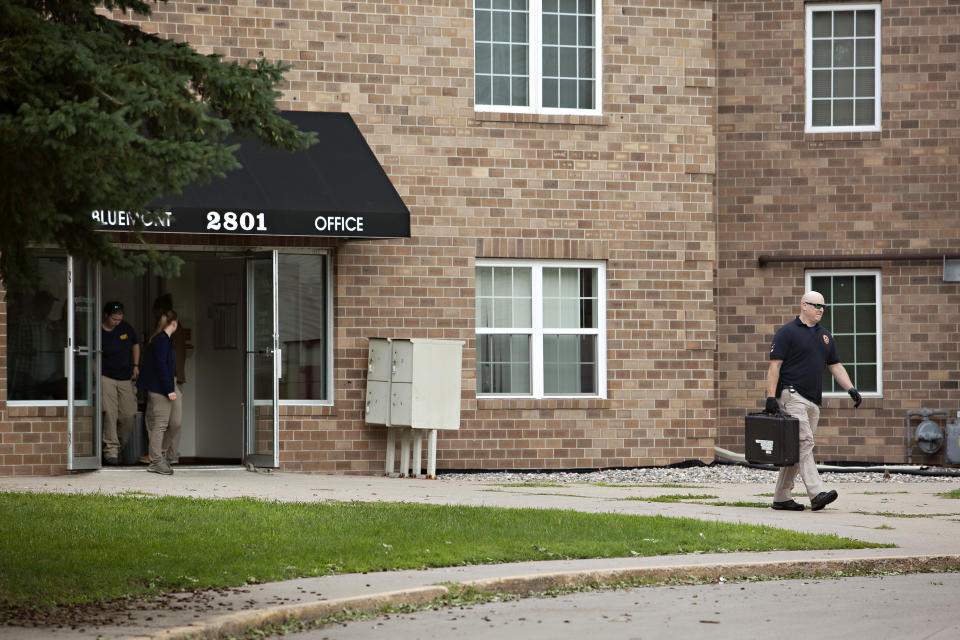 Investigators exit the Bluemont Village Apartments on Saturday, July 15, 2023, in Fargo, N.D. The suspect in a fatal shooting involving police officers a day earlier was connected to at least one apartment unit at the location. Both the suspect and one police officer were killed. (AP Photo/Ann Arbor Miller)
