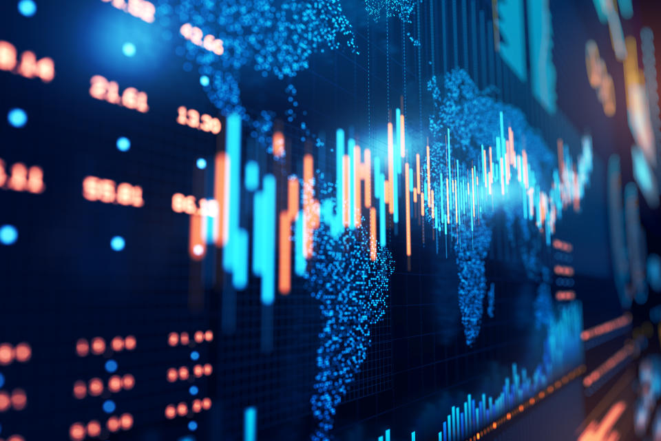 Close up of stock market chart on a glowing particle world map and trading board.