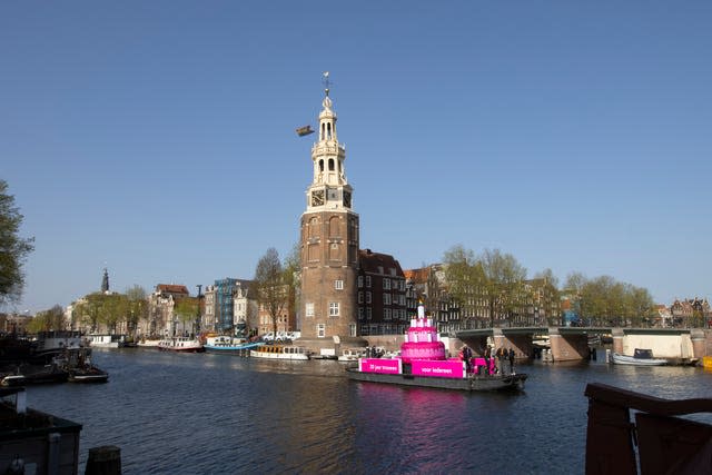 A huge inflatable pink cake with candles spouting rainbow flames glided through the Amsterdam canals as the Dutch capital celebrated the 20th anniversary of the world's first legal same-sex marriages