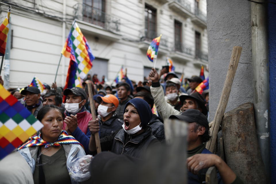 Supporters of Bolivia's former President Evo Morales, with "wiphala" flags that represent the nation's indigenous people, protest outside Congress in La Paz, Bolivia, Tuesday, Nov. 12, 2019. Former President Evo Morales, who transformed Bolivia as its first indigenous president, flew to exile in Mexico on Tuesday after weeks of violent protests, leaving behind a confused power vacuum in the Andean nation. (AP Photo/Natacha Pisarenko)