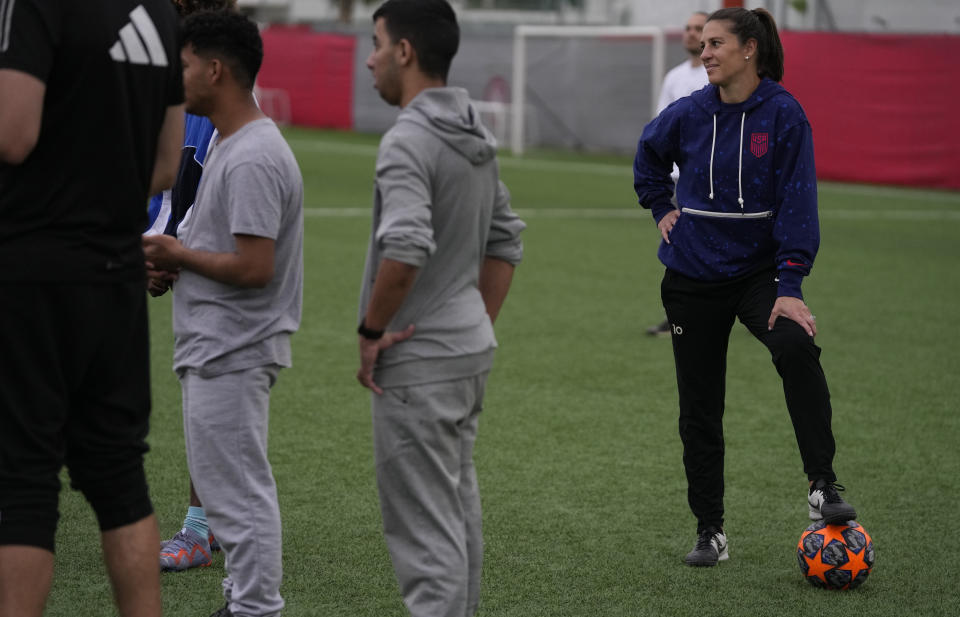 The two-time FIFA Player of the Year Carli Lloyd watches the training of young migrants at Olympiacos Training Center in Athens, Monday, April 22, 2024. Elite American athletes and coaches, including the former US soccer players Carli Lloyd and Cobi Jones, take part in the 2024 spring roster of U.S. Soccer Sports Envoys organized by the U.S. Department of State. (AP Photo/Thanassis Stavrakis)