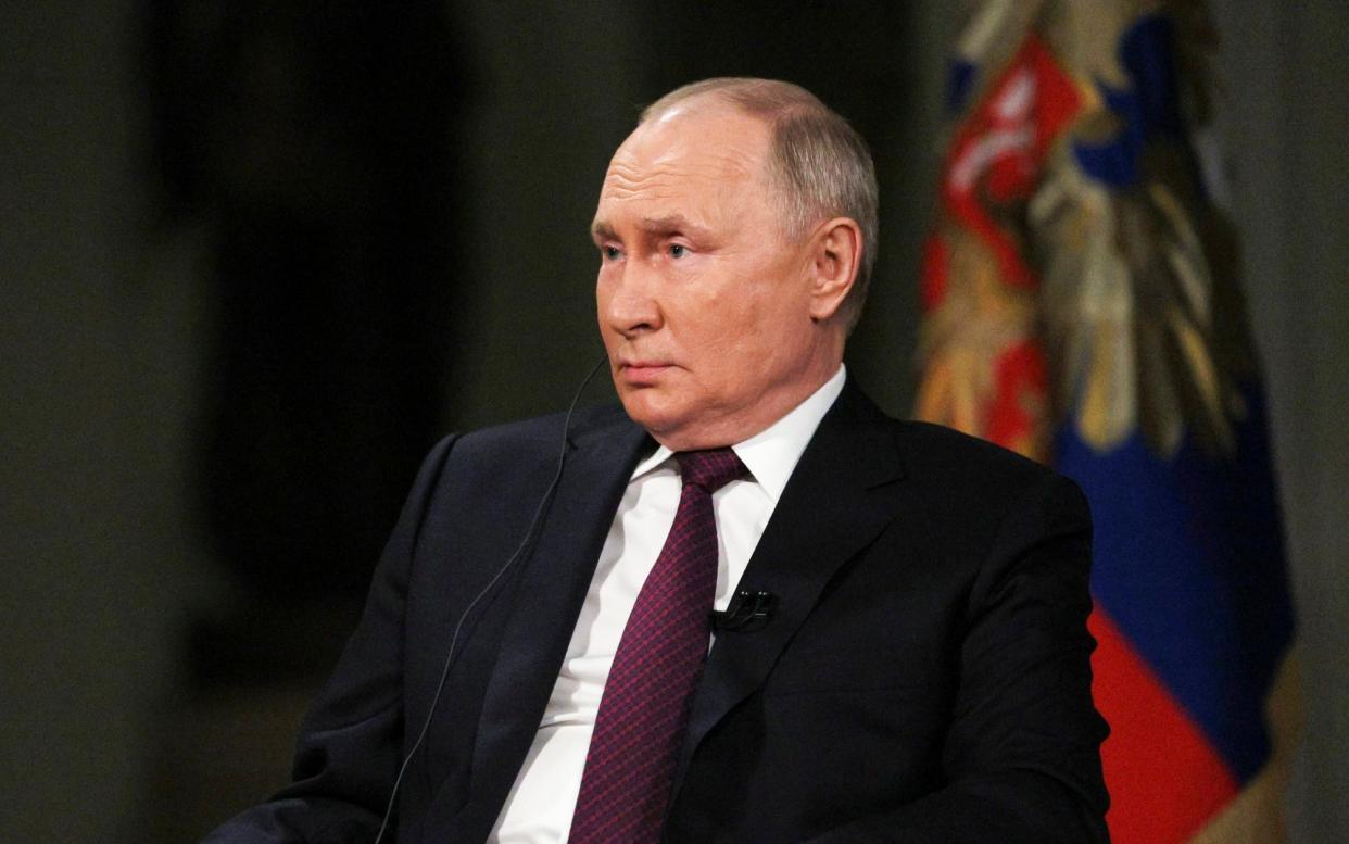 Vladimir Putin attends an interview with former Fox News host Tucker Carlson