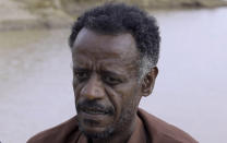 Dr. Tewodros Tefera, an Ethiopian refugee doctor who has been documenting the arrival of the bodies and their injuries, is interviewed beside the Setit river at Wad el Hilu, Sudan on Wednesday, Aug. 4, 2021. Dozens of bodies have been found floating down the Setit River, known in Ethiopia as Tekeze River, in southwestern Sudan in the past week. (AP Photo/Mohaned Awad)