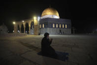 A muslim woman pray next to the Dome of the Rock Mosque in the Al Aqsa Mosque compound in Jerusalem's old city, Sunday, May 31, 2020.The Al-Aqsa mosque in Jerusalem, the third holiest site in Islam, reopened early Sunday, following weeks of closure aimed at preventing the spread of the coronavirus. (AP Photo/Mahmoud Illean)